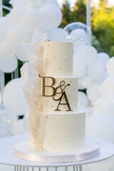 Wedding cake with letters B and A decorated with white balloons