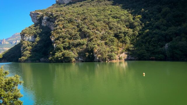 Scenic view of the Sobron Reservoir on the Ebro River, located between Alava and Burgos, Spain. Surrounded by green mountains and dramatic rock formations, this water landscape is a popular