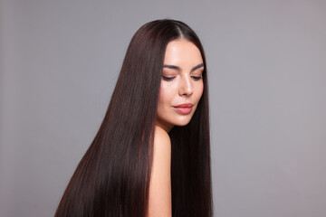 Woman with beautiful smooth hair after lamination procedure on light grey background