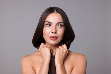 Woman with beautiful smooth hair after lamination procedure on light grey background