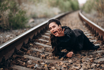 Fototapeta premium Woman in Emotional Expression on Railway Tracks Photo
