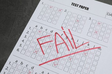 Answer sheet with word Fail on gray textured table, closeup. Student passing exam