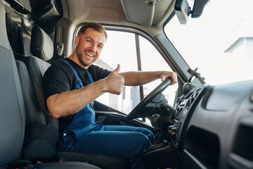 Cheerful smile, looking at the camera. Inside of the bus with delivery service man in uniform