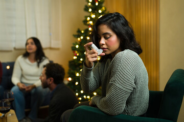 Woman using asthma inhaler during christmas holiday party