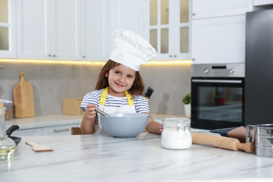Choice of profession. Little girl pretending to be chef in kitchen