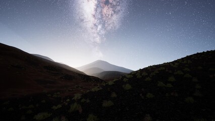 Under the expansive night sky, the milky way shines brightly, casting a soft glow over the rugged volcanic terrain. The tranquil atmosphere invites wonder and reflection in this serene setting.
