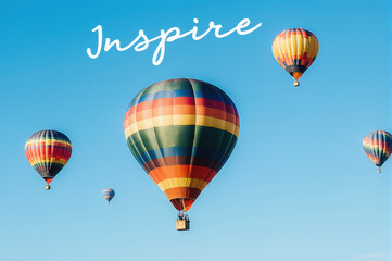 Obraz premium Colorful hot air balloon floating in clear blue sky with uplifting mood and sunlight