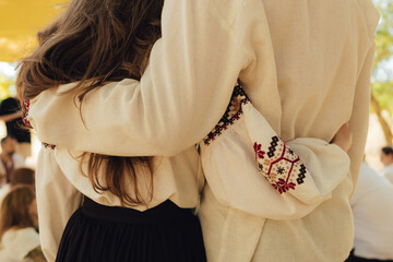 Close-up of Ukrainian traditional costume embroidered vyshyvanka blouse, woven belt kraika, folk jewelry. Ethnic festive clothing, national outfit details, cultural heritage. Part of the series