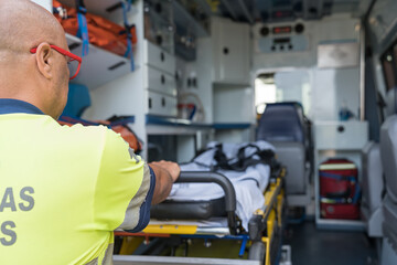 Paramedic preparing stretcher in ambulance for emergency transportation