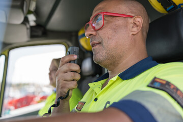 Paramedic using walkie talkie while driving ambulance during emergency