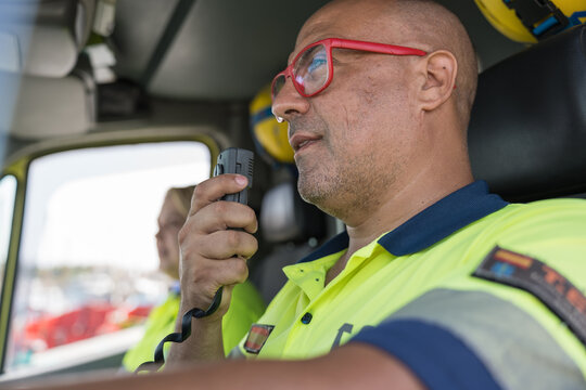 Paramedic using walkie talkie while driving ambulance during emergency