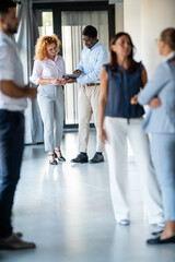 Fototapeta premium Diverse business professionals networking in modern office hallway