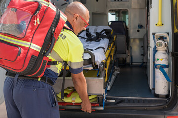 Paramedic preparing equipment inside ambulance for emergency