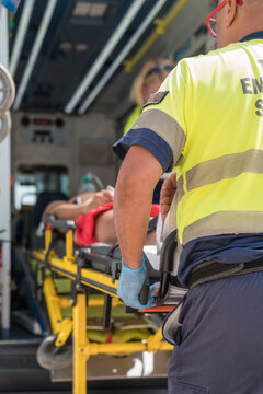 Paramedics providing first aid to injured man on stretcher in ambulance