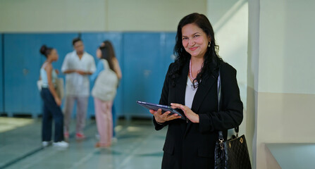 Indian mature adult busy lady woman staff hold use tab check search e-learning skill work task...