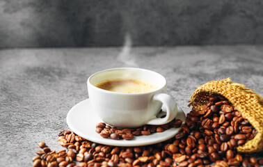 Coffee cup and coffee beans in sack on gray background, Espresso crema coffee cup aromatic