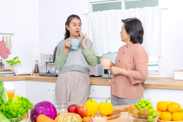 Mother and daughter in kitchen lifestyle, Asian senior woman with young adult daughter smiling together preparing healthy ingredients, fresh vegetable and fruit nutrition bonding wellness family
