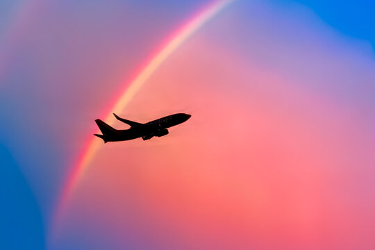 Plane flying pass a rainbow