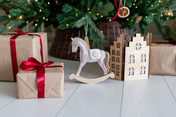 Christmas decorations: gifts, a toy horse, a folding house under the christmas tree