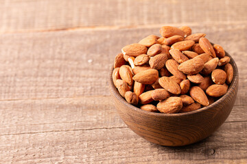 Raw peeled almonds in brown wooden bowl. Organic food concept. 