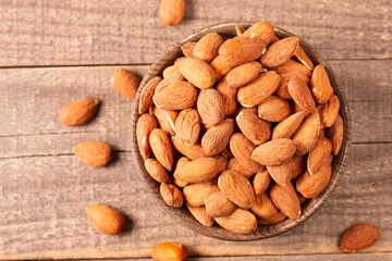 Raw peeled almonds in brown wooden bowl. Organic food concept. 