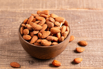 Raw peeled almonds in brown wooden bowl. Organic food concept. 
