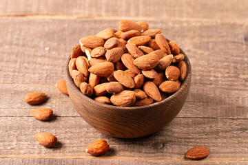 Raw peeled almonds in brown wooden bowl. Organic food concept. 