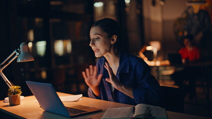 Nervous businesswoman gesturing laptop webcam working at night office closeup. 