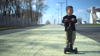 A child joyfully riding their scooter on a sunny day in a beautiful park filled with nature