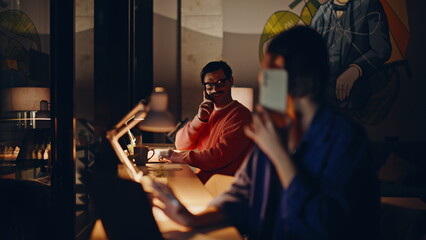 Online managers calling clients at dark office. Friendly woman talking cellphone
