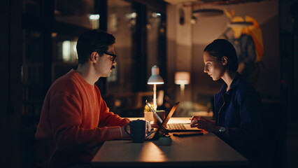 Overtime managers disappointed problem browsing laptops at night office closeup.