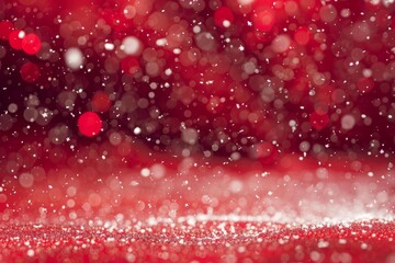 Snow is gently falling on a sparkling red christmas background with a beautiful bokeh effect, creating a magical holiday atmosphere