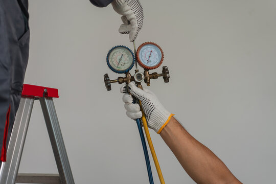 Technician Using Pressure Gauges on Refrigeration Equipment for Maintenance and Repair