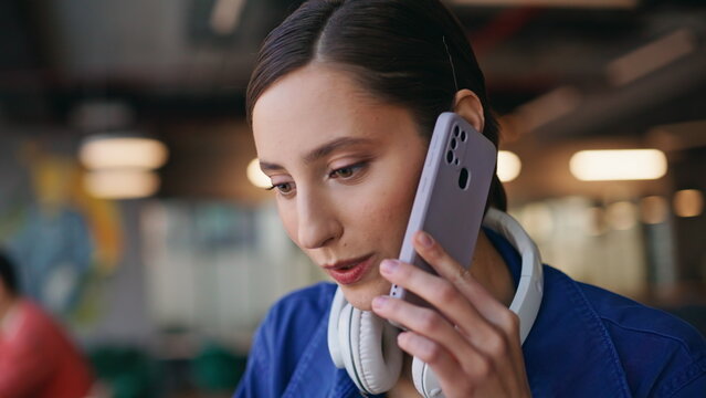 Positive student talking mobile phone sitting at cafe closeup. Portrait woman