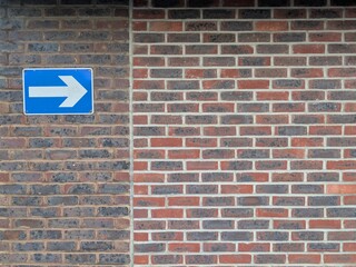One way exit arrow on a brick wall in a carp park
