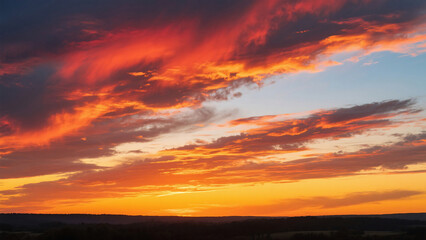A vibrant sunset with fiery orange and red clouds blanketing the sky above a dark horizon line
