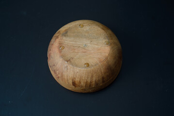 A round wooden bowl with hand-painted leaves on the inside that looks a bit like a jungle