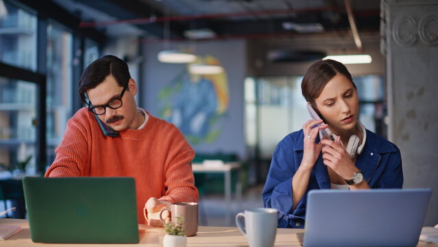 Multitasking coworkers calling smartphones in cafe closeup. Busy two employees