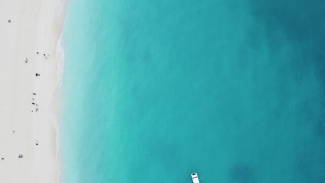 Stunning aerial footage captured directly from above, showing people sunbathing and swimming along a tropical beach. kendwa beach