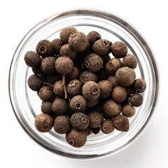 High-resolution top view of whole black peppercorns in a transparent glass bowl isolated on a white background.
