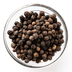 Top view of a glass bowl filled with whole black peppercorns. Aromatic spice used for cooking, seasoning, and gourmet recipes.