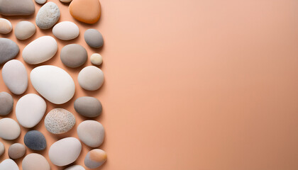 Smooth Natural Pebbles In Earthy Tones Of Beige White And Gray Arranged Along The Right Side Of A Soft Peach Background Photographed From Above With Minimalist Composition