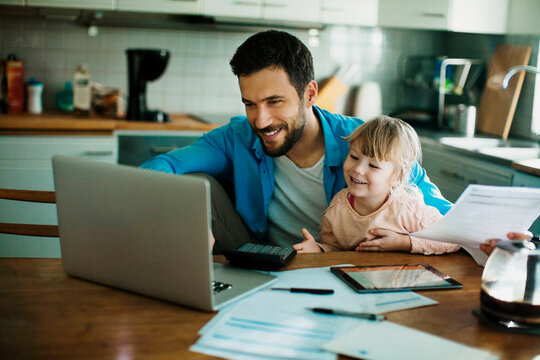 Father and daughter working together at home - Powered by Adobe