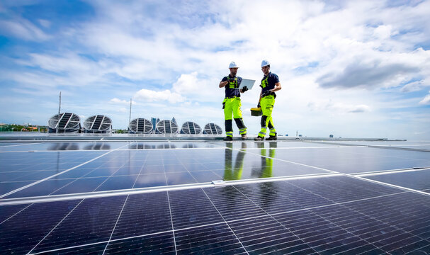 Solar panel technicians working on a rooftop installation during a sunny day - Powered by Adobe