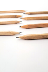 Fototapeta premium A composition of sharpened and unsharpened wooden pencils on a clean white background, creating a minimalist visual for creativity, art, and education