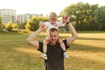 Fototapeta premium Father with his son are on the green field together