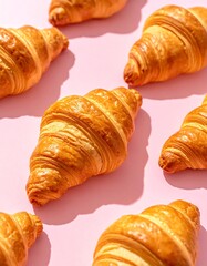 Golden Brown Croissants Arranged Artfully on a Pink Background