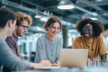 Diverse group of young professionals collaborating around a laptop