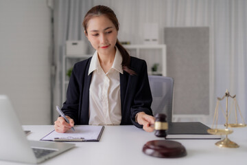 Asian Young Legal Professional Reviews Contract Documents with Gavel and Justice Scale At Law Office Ready to Provide Expert Legal Consultation