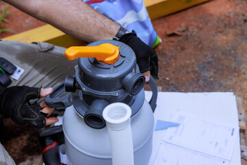Technician worker is analyzing swimming pump filter system at home, preparing for pool maintenance